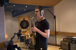 teenage boy playing trumpet in a music studio