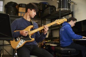 students playing electric guitar and piano