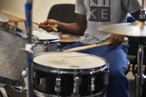 close up of boy playing drums