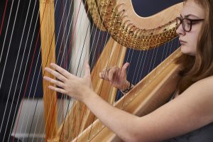 close up of girl playing harp