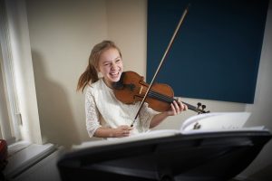 girl laughing and playing violin