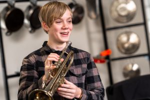 teenage boy holding a trumpet