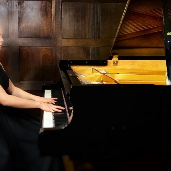 teenage girl playing a grand piano