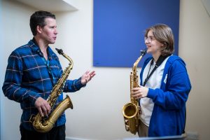 2 students playing the saxophone